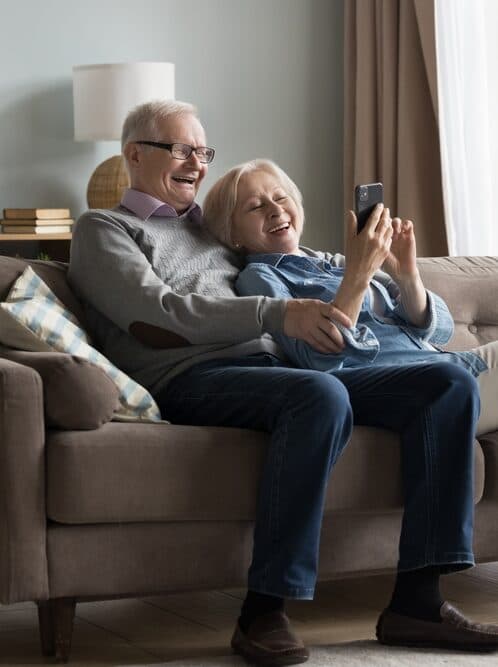 An older couple relaxing together on their sofa