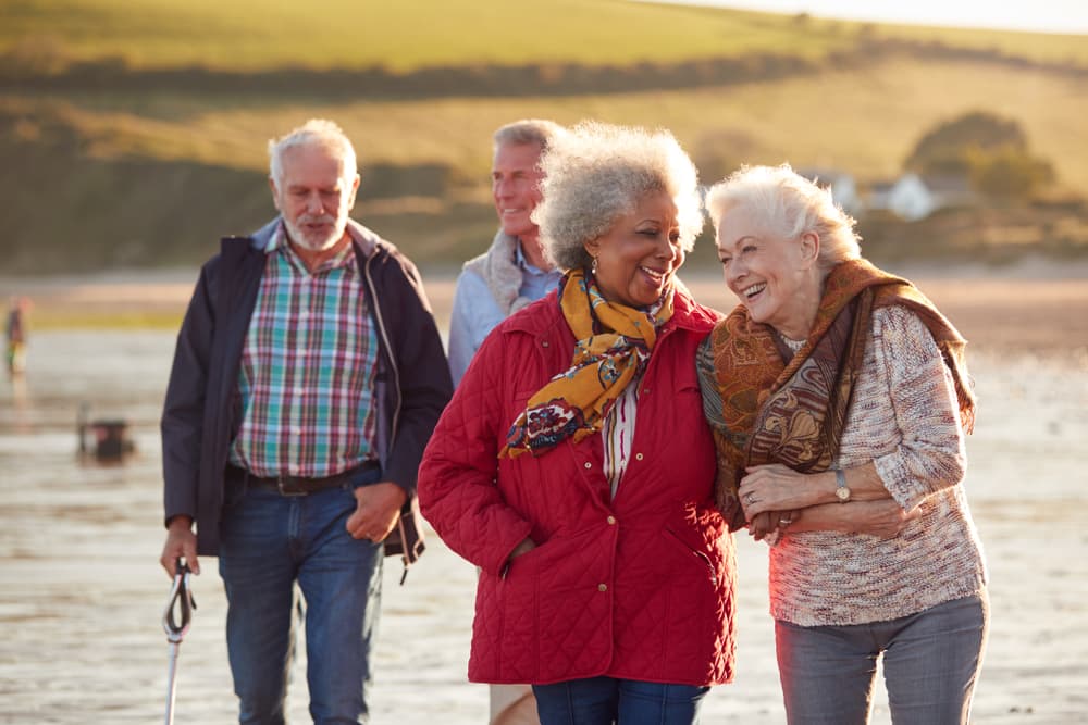 Grandparents laughing together on a beach walk